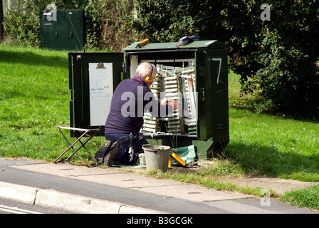 Ingénieur BT sur une boîte de jonction sur la route England UK Banque D'Images