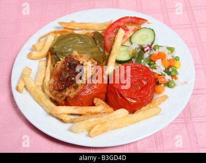 Légumes farcis gemista grec traditionnel servi par une taverne restaurant avec croustilles de pommes de terre frites, légumes et riz Banque D'Images