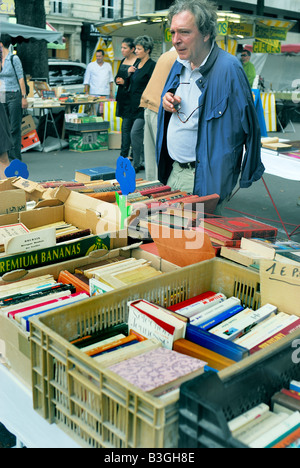 Paris France, Shopping marché aux puces, Seniors Old Man, regarder les livres à collectionner exposés dans le marché public Banque D'Images