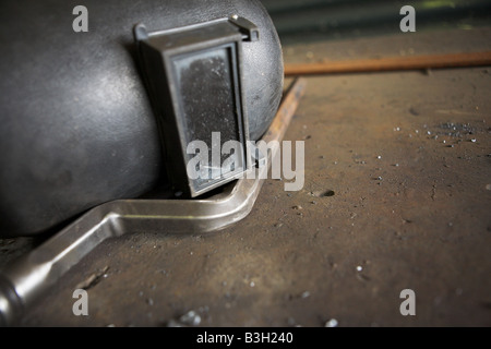 Ancien masque de soudeur allongé sur une table de travail en acier Banque D'Images