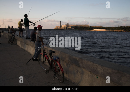 Cast pêcheurs leurs corps dans la mer depuis la Le Malecon de La Havane, Cuba. Banque D'Images