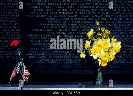 Washington, DC, Vietnam Veterans Memorial.Bouquet de jonquilles, carnation rouge et drapeau américain laissé au Vietnam Veterans Memorial comme souvenir. Banque D'Images