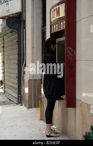 Une femme utilise un distributeur automatique dans le quartier de Chelsea à New York, le samedi 23 août 2008 Frances Roberts Banque D'Images