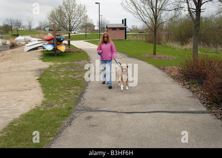 Une jeune femme marche d'un chien. Banque D'Images