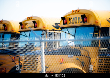 Plusieurs autobus alignés dans un dépôt prêt pour la saison de l'école. Banque D'Images