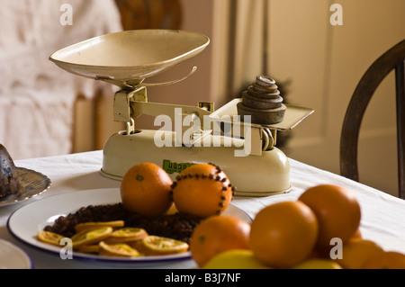 Balances à l'ancienne avec des oranges dans une cuisine de style Victorien Banque D'Images