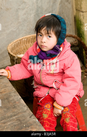 Un jeune enfant est assis à son salon de restauration de parents dans un marché alimentaire dans le nord du Vietnam Banque D'Images