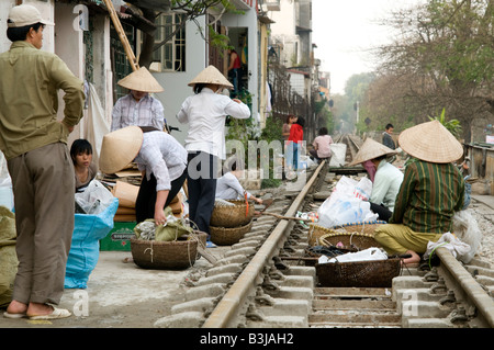 Les travailleurs de Hanoi Vietnam étaler leur marché sur la voie de chemin de fer qui va droit au coeur de la ville Banque D'Images