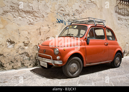 Vieille voiture Fiat 500 rouge avec barre de toit stationnés dans le sud de la ville de Lecce Italie Juin 2008 Banque D'Images