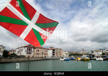 Un drapeau Basque à partir d'un mât du bateau dans le port de St Jean de Luz, une petite ville dans le Pays Basque, Sud Ouest de la France Banque D'Images