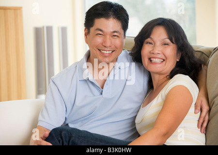 Couple relaxing in living room and smiling Banque D'Images