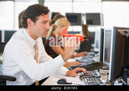 Businessman in office space with a toy airplane Banque D'Images