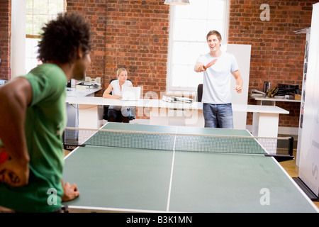 Deux hommes dans l'espace de bureau à jouer au ping-pong Banque D'Images