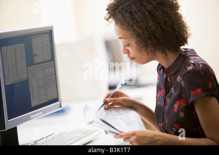 Woman in computer journal articles en encerclant roon Banque D'Images