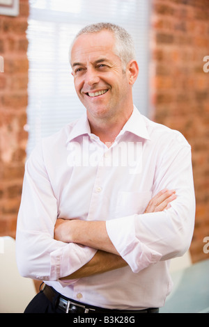 Businessman sitting in office space smiling Banque D'Images