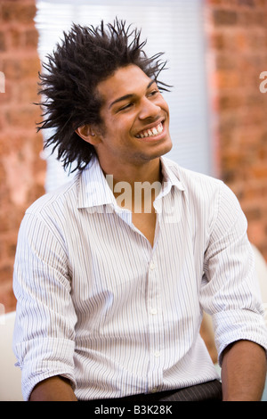 Businessman sitting in office space smiling Banque D'Images