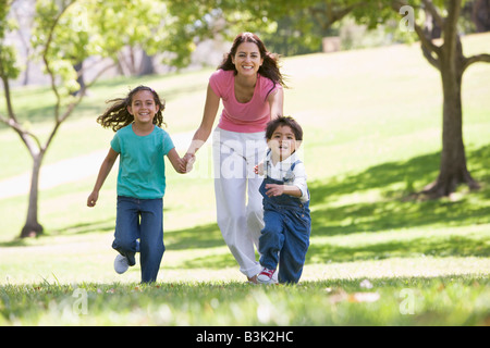 Femme avec deux jeunes enfants exécutant outdoors smiling Banque D'Images