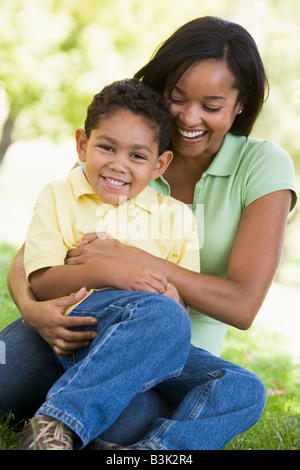 Femme et jeune garçon souriant et faire place au grand air Banque D'Images