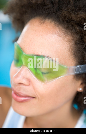 Femme assise à l'aide d'un masque pour les yeux Banque D'Images