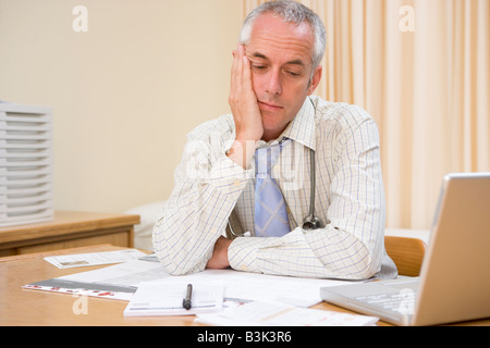 Médecin avec un ordinateur portable dans le cabinet du médecin Banque D'Images