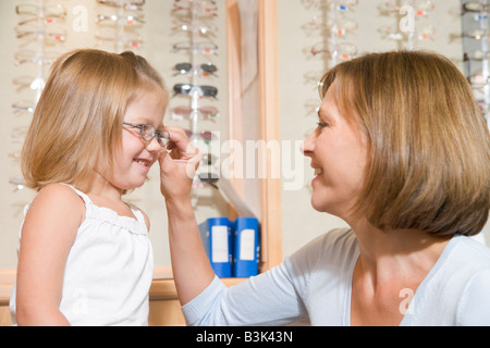 Lunettes femme essayant de fillette à optométristes smiling Banque D'Images