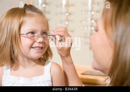 Lunettes femme essayant de fillette à optométristes smiling Banque D'Images