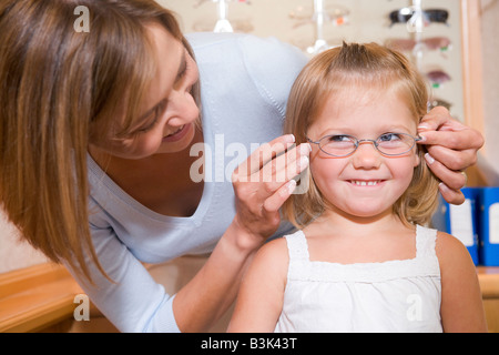 Lunettes femme essayant de fillette à optométristes smiling Banque D'Images