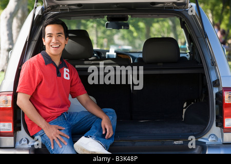 Homme assis à l'arrière du van smiling Banque D'Images