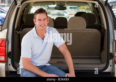 Homme assis à l'arrière du van smiling Banque D'Images