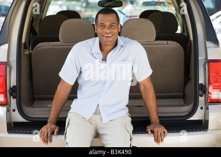 Homme assis à l'arrière du van smiling Banque D'Images