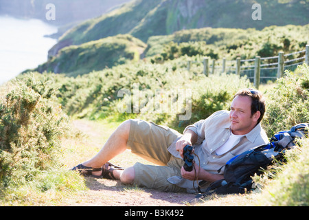 Man relaxing on cliffside path Banque D'Images