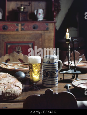 UNE TASSE EN GRÈS À BIÈRE AVEC COUVERCLE FERMÉ ET UN VERRE DE BIÈRE SUR UNE ANCIENNE TABLE DE CUISINE ALSACE FRANCE EUROPE Banque D'Images