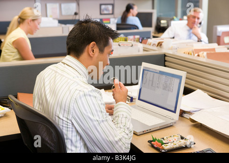 Homme d'affaires dans l'armoire à l'ordinateur portable de manger des sushis Banque D'Images