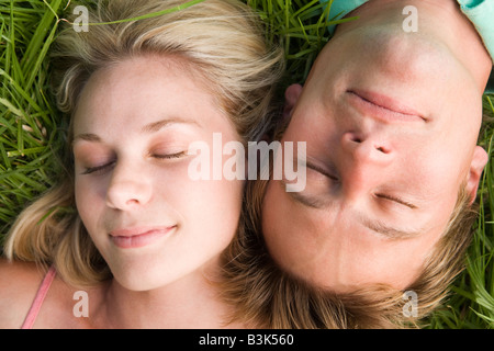 Couchage Couple lying in grass Banque D'Images