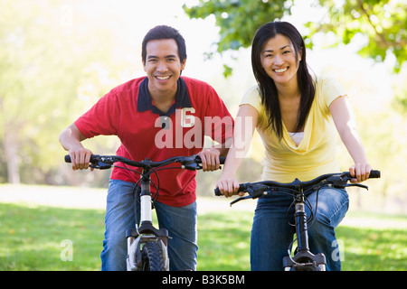 Couple on bikes outdoors smiling Banque D'Images