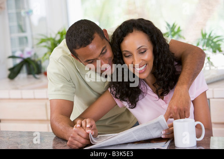En couple avec cuisine journal et café smiling Banque D'Images