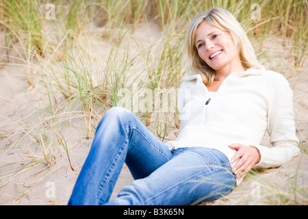 Smiling Woman lying on beach Banque D'Images