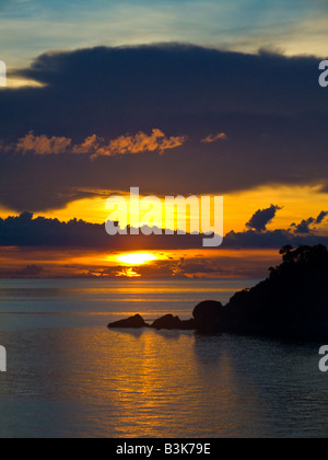 Coucher de soleil en mer avec silhouette de rochers en premier plan Koh Tao Thaïlande JPH0100 Banque D'Images