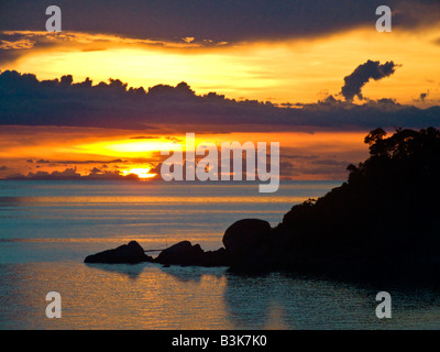 Coucher de soleil en mer avec silhouette de rochers en premier plan Koh Tao Thaïlande JPH0102 Banque D'Images