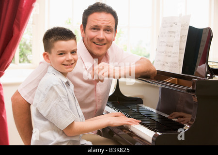 L'homme et jeune garçon jouant du piano et souriant Banque D'Images