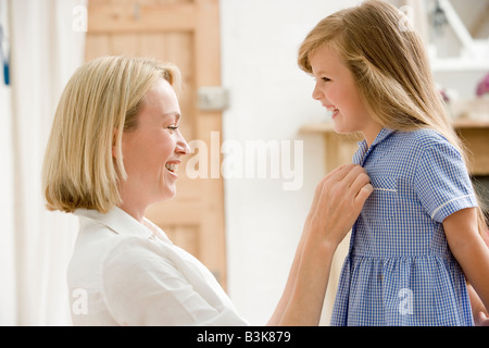 Femme en face couloir fixant les jeunes robe de fillette et souriant Banque D'Images