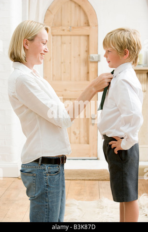 Femme en face du jeune garçon fixation couloir tie and smiling Banque D'Images