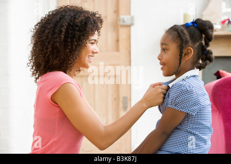 Femme en face couloir fixant les jeunes robe de fillette et souriant Banque D'Images