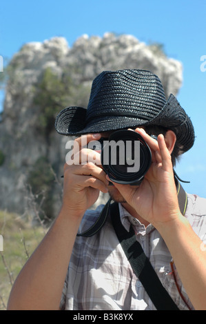 Portrait de jeune homme à l'aide de caméras professionnelles nature background Banque D'Images