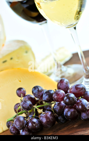 Wineglasses avec du vin rouge et blanc et d'un assortiment de fromages Banque D'Images