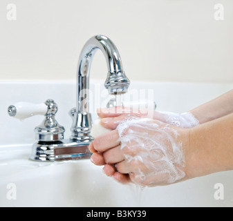 Enfant lave-mains avec du savon sous l'eau courante Banque D'Images