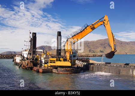 Un front end digger sur une barge spud et utilisé pour les opérations de dragage. La mer de matériel bas chargé dans un chaland. Banque D'Images