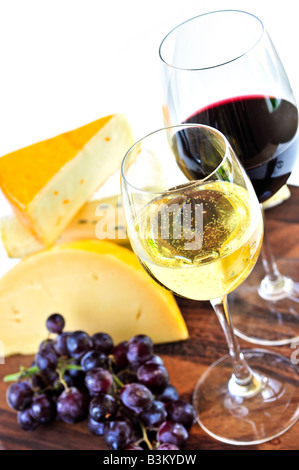 Wineglasses avec du vin rouge et blanc et d'un assortiment de fromages Banque D'Images