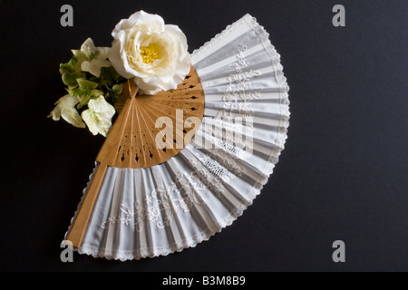 Pliage blanc oriental fan sur un fond noir avec fleur Banque D'Images