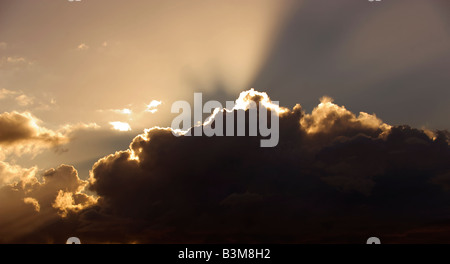 Les rayons lumineux d'un soleil couchant éclatent d'un nuage de tempête Banque D'Images